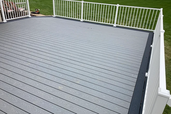 Larger gray composite deck with white railing - Hard Decks Larger gray composite deck with white railing