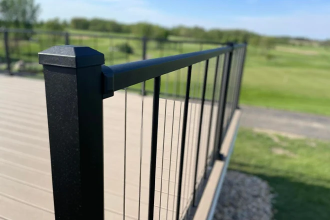 Closeup of black metal railing with post caps