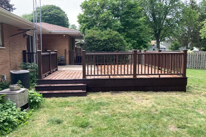 Dark stained wood railing on low deck