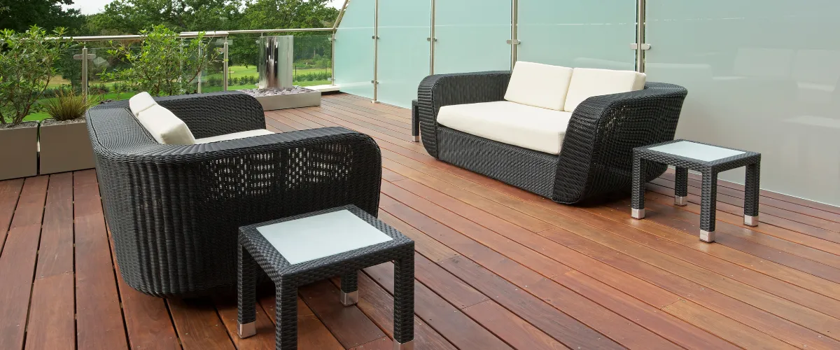 Outdoor deck with black wicker furniture and glass-top tables