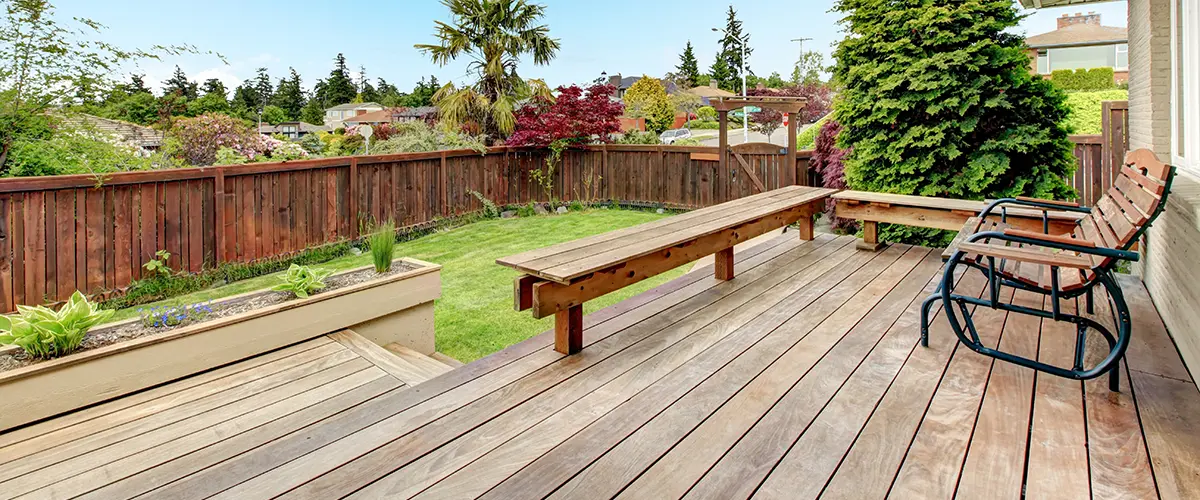 Deck Building in Roscoe, IL 2 Backyard wood deck with built-in bench and green lawn view