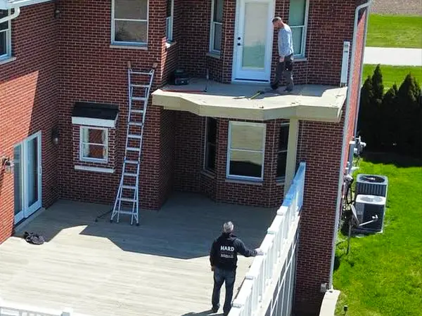 NADRA Certified Deck Safety Inspection 11 Large custom deck installation in progress on red brick home with elevated platform and white railing system