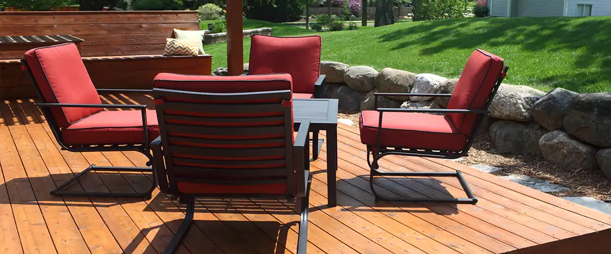 Wooden deck with red cushioned patio chairs