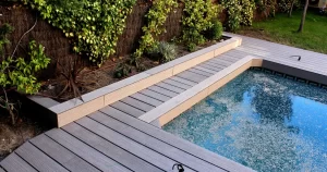 A composite deck surrounds a central pool, creating a relaxing outdoor space.